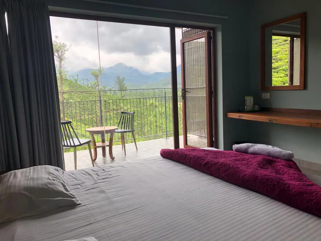 Bed facing a tea estate balcony